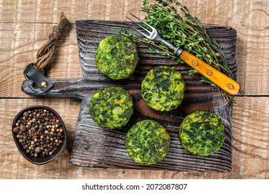 Vegetarian vegetable burgers patty with herbs on wooden board. Wooden background. Top view - Powered by Shutterstock