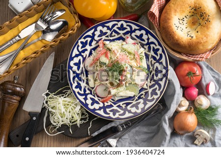Vegetarian vegetable salad of radish and sour cream in a plate with a traditional Uzbek pattern