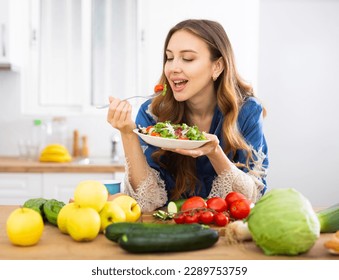 Vegeterian woman standing at table in kitchen - Powered by Shutterstock