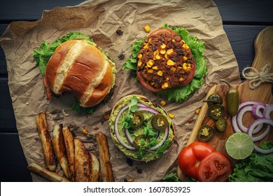 Veggie Burger On A Dark Background With Potato Veggies And Vegetables On The Background. Overhead Shot.