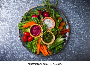 Veggie Crudite Platter With Three Different Dips On The Metal Background