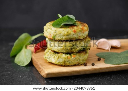 Veggie patties or cutlets for vegan burgers on wooden cutting table, white marble background.