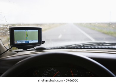 Vehicle Dashboard With GPS And View Through Windshield Of Highway Ahead.