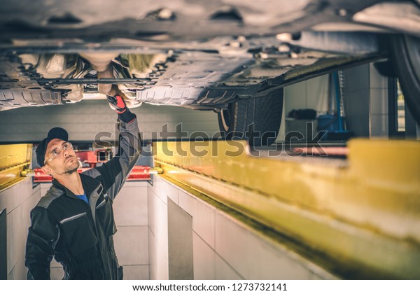 Vehicle\
Diagnostic Station. Caucasian Auto Service Worker Checking Car\
Under Carriage Looking For Potential\
Issues.
