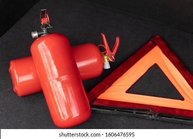 Vehicle Emergency Tools Kit, Red Warning Triangle, And Fire Extinguisher In The Trunk Of The Car. Elements Of The Essentials For A Passenger Car