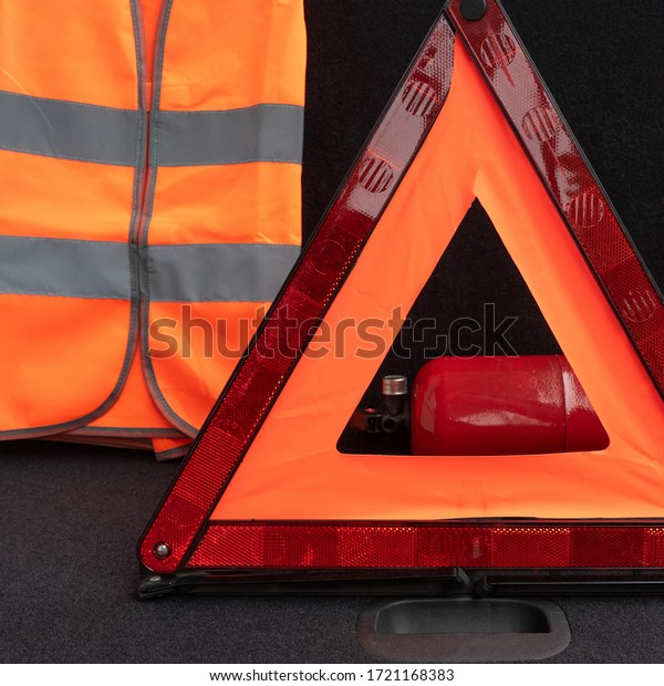 Vehicle emergency\
tools kit, Red warning triangle, high-visibility vest and fire\
extinguisher in the trunk of the car. Elements of the essentials\
for a passenger\
automobile
