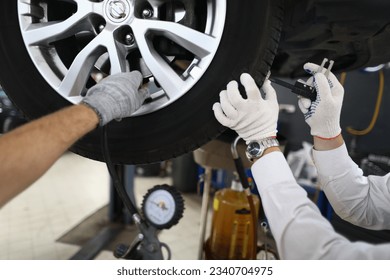 Inspección del vehículo El técnico automático repara el neumático del automóvil en la estación de servicio