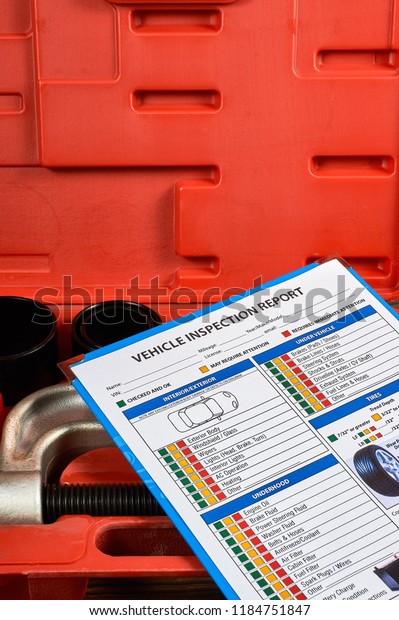 Vehicle vehicle inspection report form\
against the background of automotive tools. Close\
up.