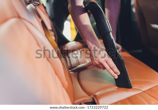 vehicle interior vacuum\
cleaning. Detail shot of an industrial vacuum cleaner cleaning a\
car seat.