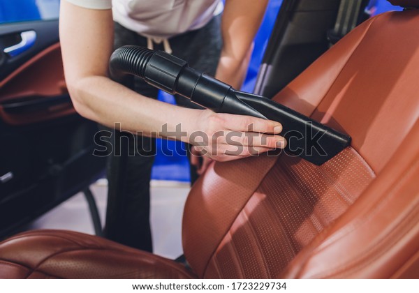 vehicle interior vacuum\
cleaning. Detail shot of an industrial vacuum cleaner cleaning a\
car seat.
