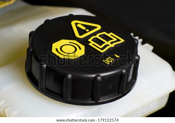 Vehicle maintenance\
fragment, Brake and clutch fluid check cap with black cap and\
yellow warning\
information.