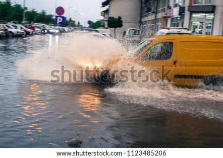 The vehicle passes through a flooded area, a flooded street.