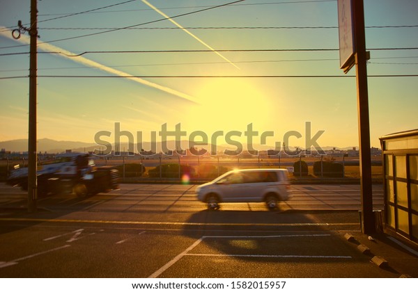 a vehicle\
passing by the airport with the\
sunset.