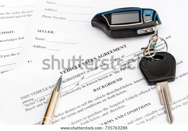 Vehicle sales agreement with pen and car remote\
control. Business\
concept.