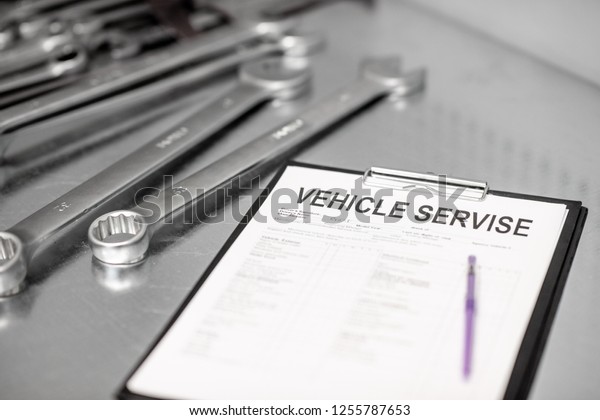 Vehicle service agreement on the table with\
stainless wrenches\
indoors