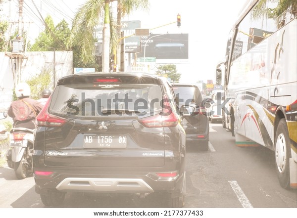 Vehicle\
stopped at red light, yogyakarta, indonesia, july 12, 2022 or\
kendaraan or mobil dan motor berhenti di lampu merah or trafic\
light, pada jam sibuk,  dipotret dari dalam\
mobil