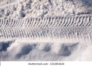 Vehicle And Tractor Tire Tread Imprints On  The Snowy Road In Winter, Close Up Top View. One Horizontal Line With Copy Space At The Top And Bottom.