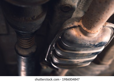 Vehicle underbody exhaust pipe, catalyst, resonator, exhaust system. Old parts require repair and replacement. Car service and maintenance. Standards and technical condition. selective focus - Shutterstock ID 1986004847