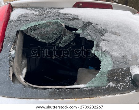 Vehicle's back window is completely broken, revealing the interior, a common sight of car damage, vandalism, or theft