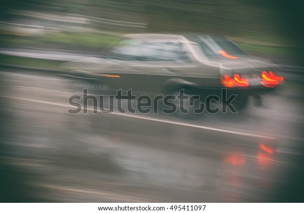 Vehicles driving in the city at night in the\
rain, blurred\
background