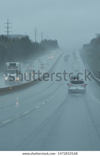 Vehicles with Headlights on at a Busy Highway\
During a Rainstorm