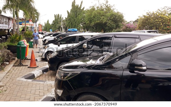 Vehicles are parked at the rest stop or mobil\
parkir di parking lot terbuka dengan berjejer dengan rapi. November\
1, 2021, yogyakarta,\
Indonesia