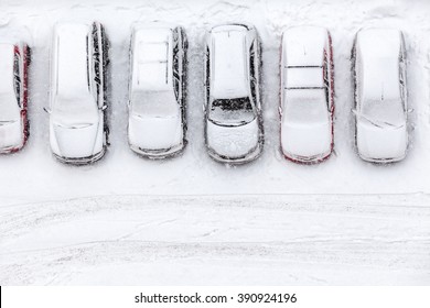 Vehicles standing at winter parking lot covering with snow, top view, copyspace - Powered by Shutterstock