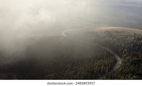 Veiled in Mist: Aerial View of a Road Through Forested Hills - Powered by Shutterstock