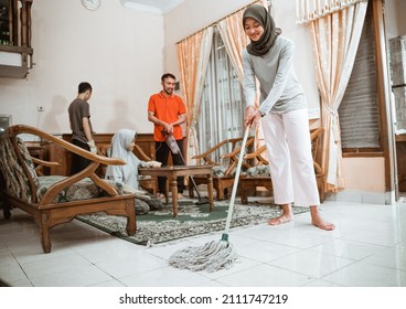 Veiled Mother Mopping The Floor While Cleaning The House Together