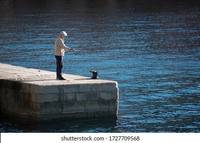 Veli Losinj, Croatia - May 4. 2020: Older Man Fishing In Veli Losinj