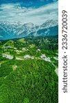 Velika Planina or Big Pasture Plateau in the Kamnik Alps, Slovenia. Mountain cottage hut or house on green hill. Alpine meadow landscape. Eco food production, aerial view.