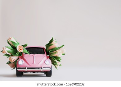 Veliky Novgorod, Russia - October 5, 2019: Pink retro toy car with flowers. March 8, February 14, Valentine's Day card, Women's Day, holiday concept.