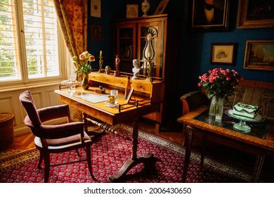 Velke Brezno, Czech Republic, 26 June 2021: chateau Velke Brezno, castle interior with baroque furniture, cabinet with wooden writing desk, armchair on carpet near windows, figurines and documents.