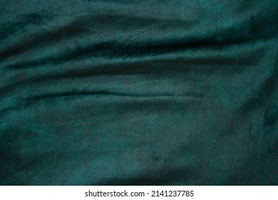 velour fabric texture, background, green. Velvet velour cloth background with glowing light and dark shadows. Background for theater and fashion design themes