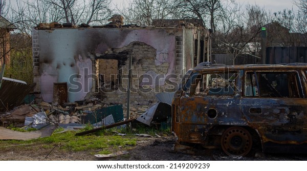 Velyka Dymerka, Kyiv region, Ukraine - April\
2022: War Ukraine Russia. The ruins of a house and a blown up car\
of civilians after the bombing by the Russian army. Damaged car and\
house after a missile