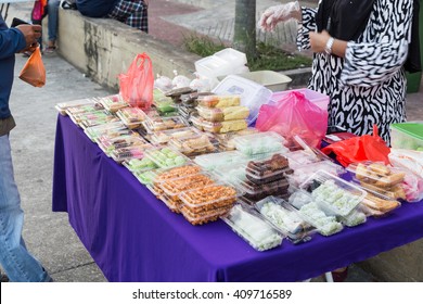 Vendor selling assorted Malay halal sweet cakes food at street stall