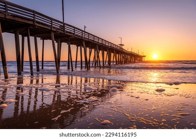 Venerable wood fishing pier in Virginia Beach at sunrise.