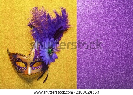 Venetian carnival mask with copy space over bright yellow and purple glitter background. Carnival celebration concept