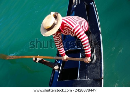 Venetian gondolier with hat rowing on gondola on grand canal in Venice in Italy in Europe