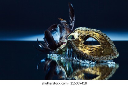 The Venetian Mask With Feather On A Mirror Table