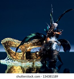 The Venetian Mask With Feather On A Mirror Table