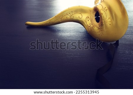 Venetian mask with a long nose over dark background