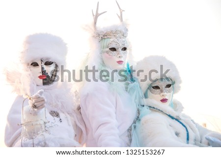 Venice Carnival 2019.  Three women wearing winter white Venetian masks and costumes