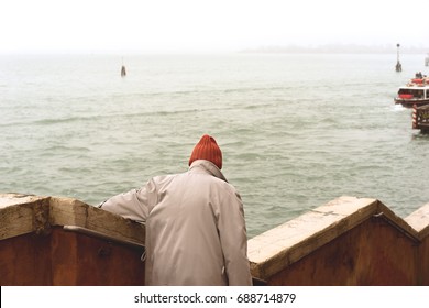 VENICE, FEBRUARY 2016: An Old Man Wearing A Red Beanie Walking Down Some Stairs In Venice