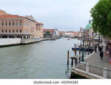Venice, Italy- April 13, 2016: People walking along the beautiful canal in Venice in the morning.