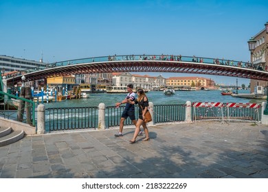 Venice, Italy - August 24, 2018: Tourists Walking Along The Banks Of The Grand Canal With The Constitution Bridge In The Background In The City Of Venice, Italy