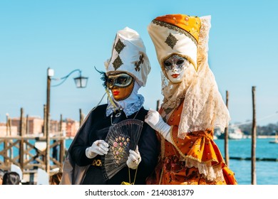 Venedig Italien - 28. Februar 2022 - Maske Menschen mit einem flammenden Kostüm, die sich für den Karneval an einem sonnigen Tag posieren