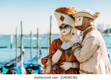 Venedig Italien - 28. Februar 2022 - Maske Menschen mit einem flammenden Kostüm, die sich für den Karneval an einem sonnigen Tag posieren