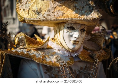 Venedig Italien - 28. Februar 2022 - Maske Person mit einem flammenden Kostüm, das für den Karneval an einem sonnigen Tag posiert