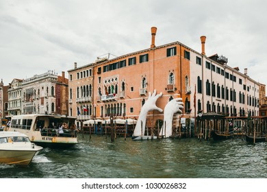 VENICE, ITALY - JULY 02, 2017: Support by Lorenzo Quinn. Gigantic hands rise from water to support the Ca’ Sagredo Hotel, a statement of the impact of climate change and rising sea levels.